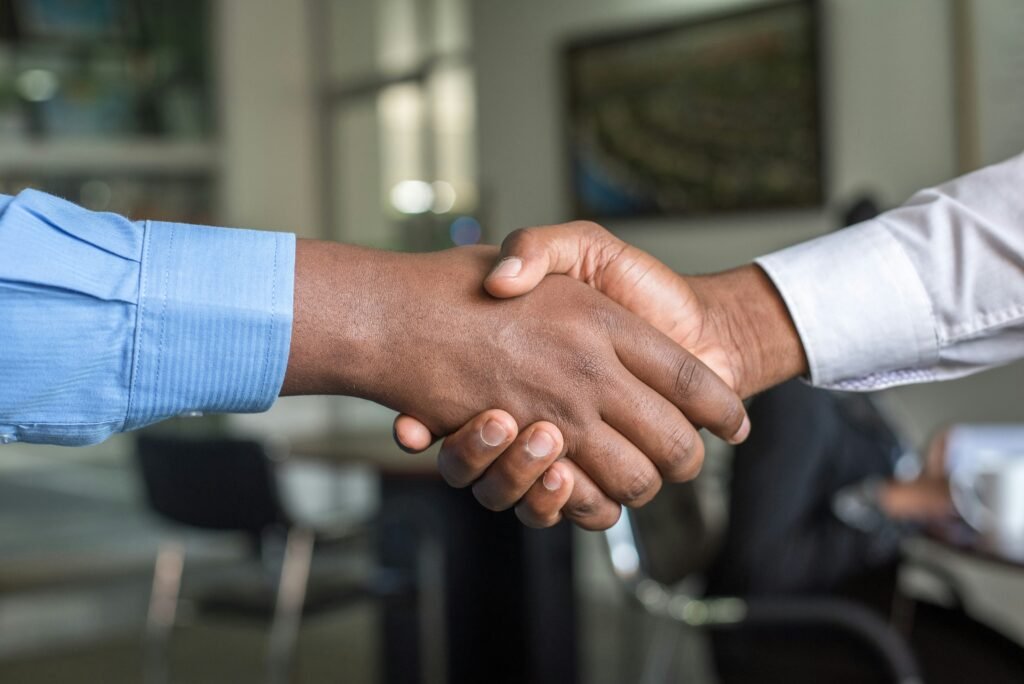 Two hands shaking in a handshake, symbolizing partnership, clarity, and calm decision-making in business and personal finance.