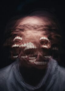 A blurred, distorted image of an angry face captured using slow shutter speed and long exposure, creating a sense of emotional chaos and loss of control.